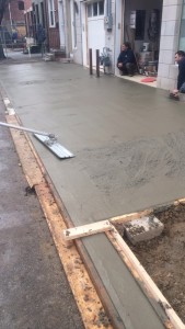 Bull float being used for finishing concrete sidewalk in Philadelphia